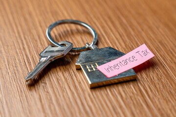 A house-shaped keychain with a key and a note 