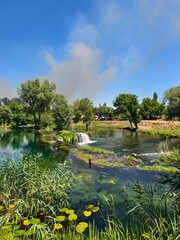 Serene Nature Scene with Waterfall and Tranquil Reflective Pond