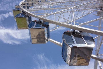 Summer, city park. Big Ferris wheel with blue sky