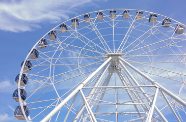 Summer, city park. Big Ferris wheel with blue sky