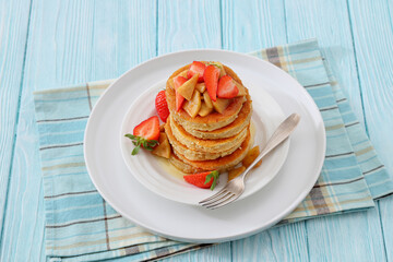 pancakes topped with apple slices and strawberries