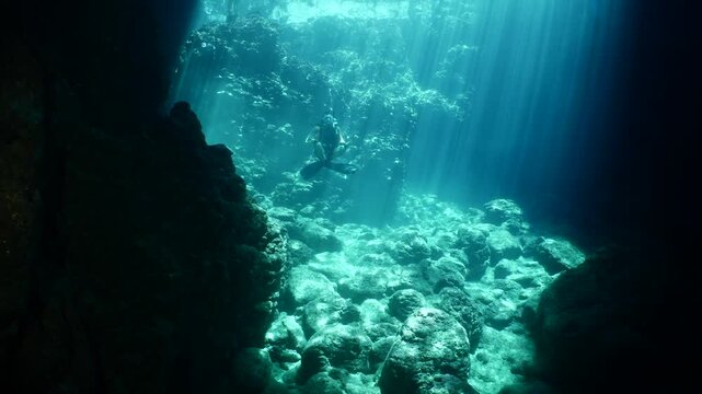 scuba diver howers like budha underwater with waves under sun beams and rays yogo meditation