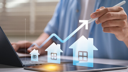 Real estate market growth Concept. Man rising home prices with digital graph and house icons for investment strategy planning, housing value trends and property business analysis in urban development