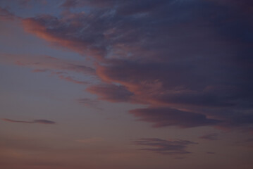 Radiant purple, orange, and pink clouds painting the sky during sunrise, creating a breathtaking...