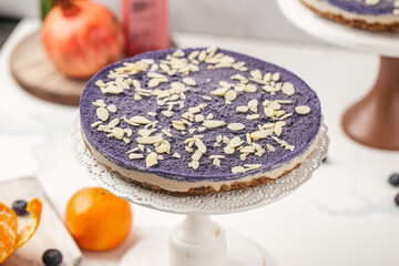 Blueberry cake with almond flakes on stand with fruits and smoothies