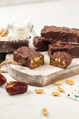 Chocolate peanut protein bars with dates on wooden board