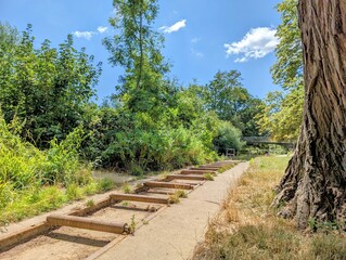Dried out run-off channel connecting to a river or collection pool in bright summer sunlight in Oxford, UK