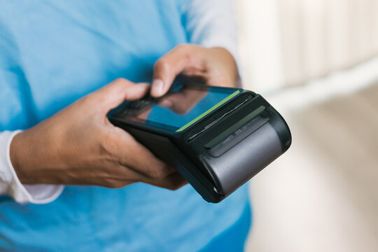 Nurse accepting payment using contactless pos terminal