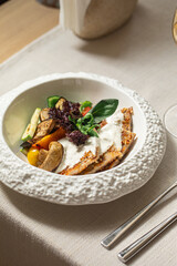 Turkey schnitzel with white sauce and grilled vegetables on white plate