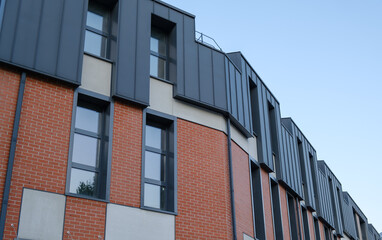 A brick building with a black roof and windows