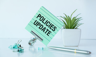 A green piece of paper with the word Policies Update written on it