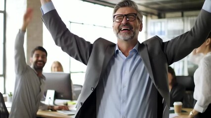 Successful mature businessman with glasses celebrating a big win with his happy team in a modern office - Powered by Adobe