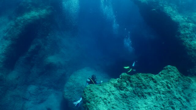 scuba divers are exploring the reefs and topography underwater
