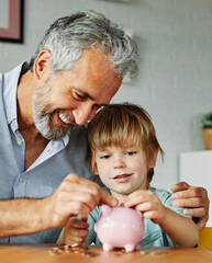 Grandparent And His Grandson Putting Coin Money In Piggybank  At Home. Personal Savings, Bank...