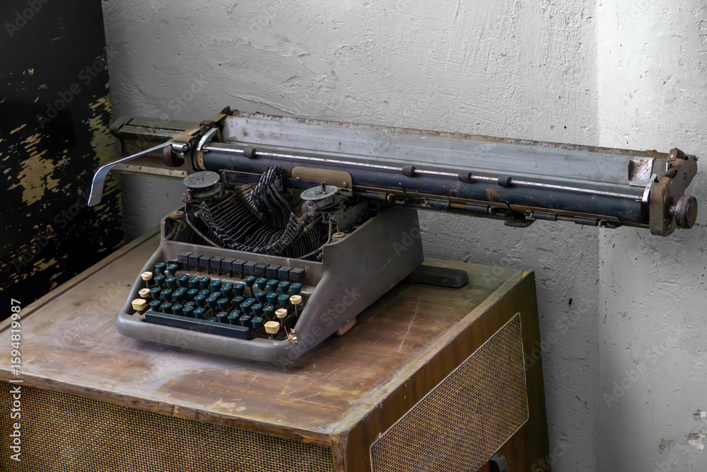 Fototapete rusty typewriter with extended mechanism in an abandoned room.