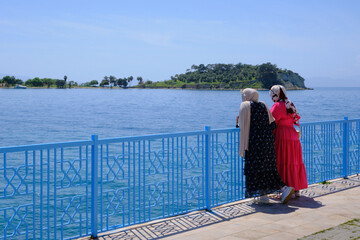 Two local girls looking at the Mediterranean sea at the Turkish coast of Kusadasi, Turkey.