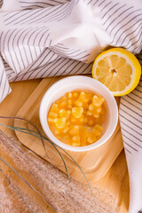 Vitamins and supplements. Lemon gummies or multivitamins in a white bowl on a light background.