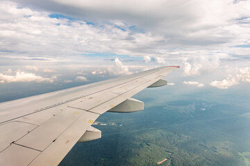 Obraz premium View from the airplane window at a beautiful cloudy sky and the airplane wing
