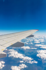 Obraz premium View from the airplane window at a beautiful cloudy sky and the airplane wing
