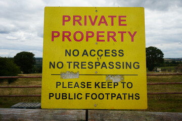 Obraz premium Codnor, Derbyshire, England - July 16 2025: Private Property No Trespassing Sign on Wooden Fence in Rural Countryside
