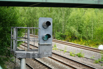 Codnor, Derbyshire, England – July 16 2025: Railway signal light and tracks under bridge in Codnor Woodland.