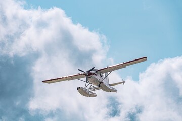 Red and white floatplane captured mid-flight with its propeller spinning and floats clearly...