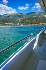 Partial View of Boat Deck with Railings and Scenic Sea and Mountain Background