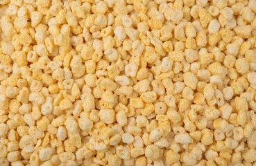 Fototapeta premium Golden puffed rice cereal texture close-up. Light, airy, crispy grain snack, uniform pattern. Healthy breakfast ingredient, organic food. Sweet honey sugar coating, perfect for dieting, nourishment.