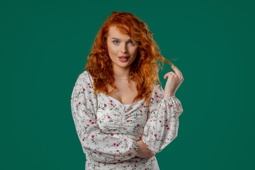 Playful Red-haired Curly Woman Smiling, Flirting To Camera On Green Studio