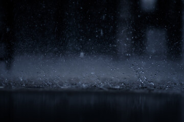 heavy raining make many small splash crown from water droplets drop down to the concrete floor in blue tone color scene