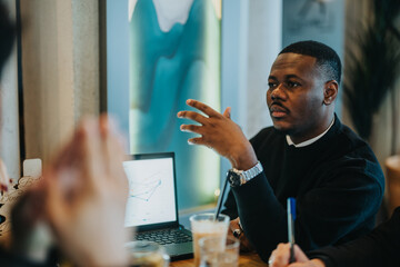 A group of professionals engages in a productive discussion around a table. A laptop displaying a graph is visible, enhancing the collaborative and strategic atmosphere of the meeting.