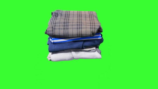 A neat stack of folded clothes in various colors and patterns on a green screen. Suitable for fashion, retail, and laundry-themed projects, ideal for compositing.