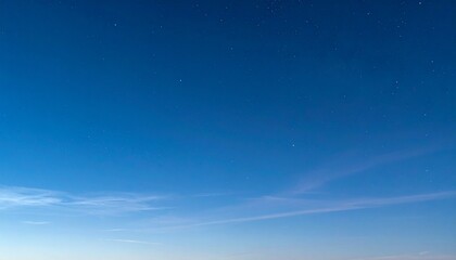 Gradient blue sky at twilight with wispy clouds, blending into a starry night, crystal-clear