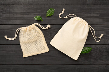 Small eco sacks on wooden background, top view