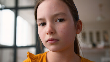Close up disappointed little Caucasian child girl getting upset frustrated at home. Sad daughter...