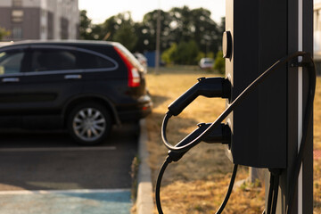 Electric car charging station in courtyard at sunset with space for text.