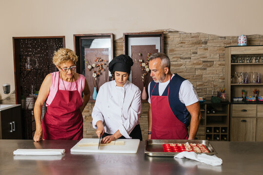 Chef teaching students how to prepare ingredients during cooking class