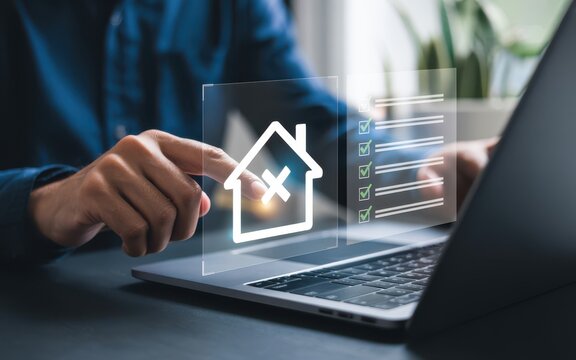 Real estate transaction digital interface with hand interacting on laptop keyboard showing holographic 3D house icon and transparent document with checkmarks