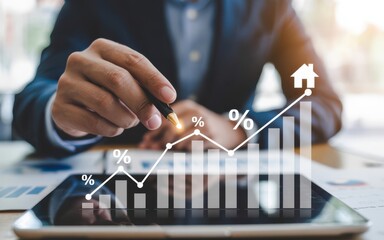 Hand interacting with digital tablet displaying ascending white line graphs with house and percentage icons, warm golden highlights and blurred background emphasizing real estate growth