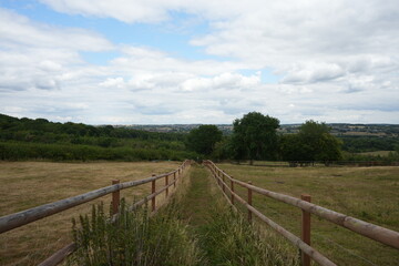 Fototapeta premium Picturesque view of a countryside footpath with wooden fence and rolling hills in Codnor, Derbyshire, England