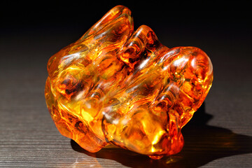 Amber with patterns on the black background. Sun stone. Fossil fossilized resin. semi-precious mineral. Natural material for jewelry. Copal. Science.  Polished amber stone.