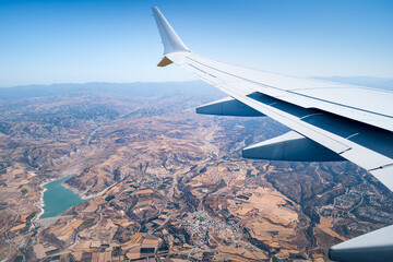 Wing of an airplane flying over a holiday island, Cyprus.