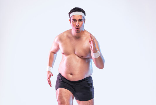 Overweight man running to lose weight and get in shape. Fat man training outdoors as part of fitness and health journey. Real effort to change lifestyle through exercise.