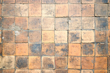 Orange brown white beige old shabby worn out floor tiles with damages cracks dirt caverns potholes...