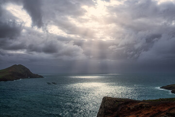Dramatic ocean shoreline landscape with stormy sky and sunrays