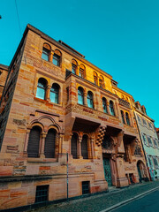 Fototapeta premium Old architectural building in city against blue bright sky. Cityscape