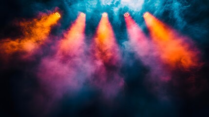 Colorful spotlights shine through a smoky haze creating a dynamic and vibrant visual display perfect for backgrounds or artistic concepts with dramatic lighting effects.