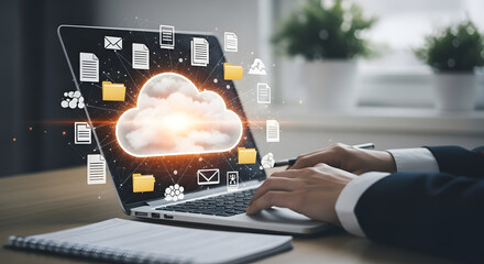 Businessperson using a laptop with a cloud computing graphic overlay.