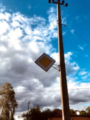 Warning sign on a utility pole under a cloudy sky