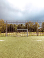Fototapeta premium Soccer goal on a field under a cloudy sky at dusk